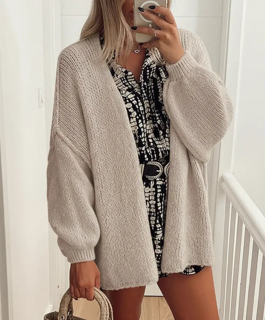 Comfy Oversized Cardigan worn over a patterned dress, showcasing its relaxed fit and soft knit texture.